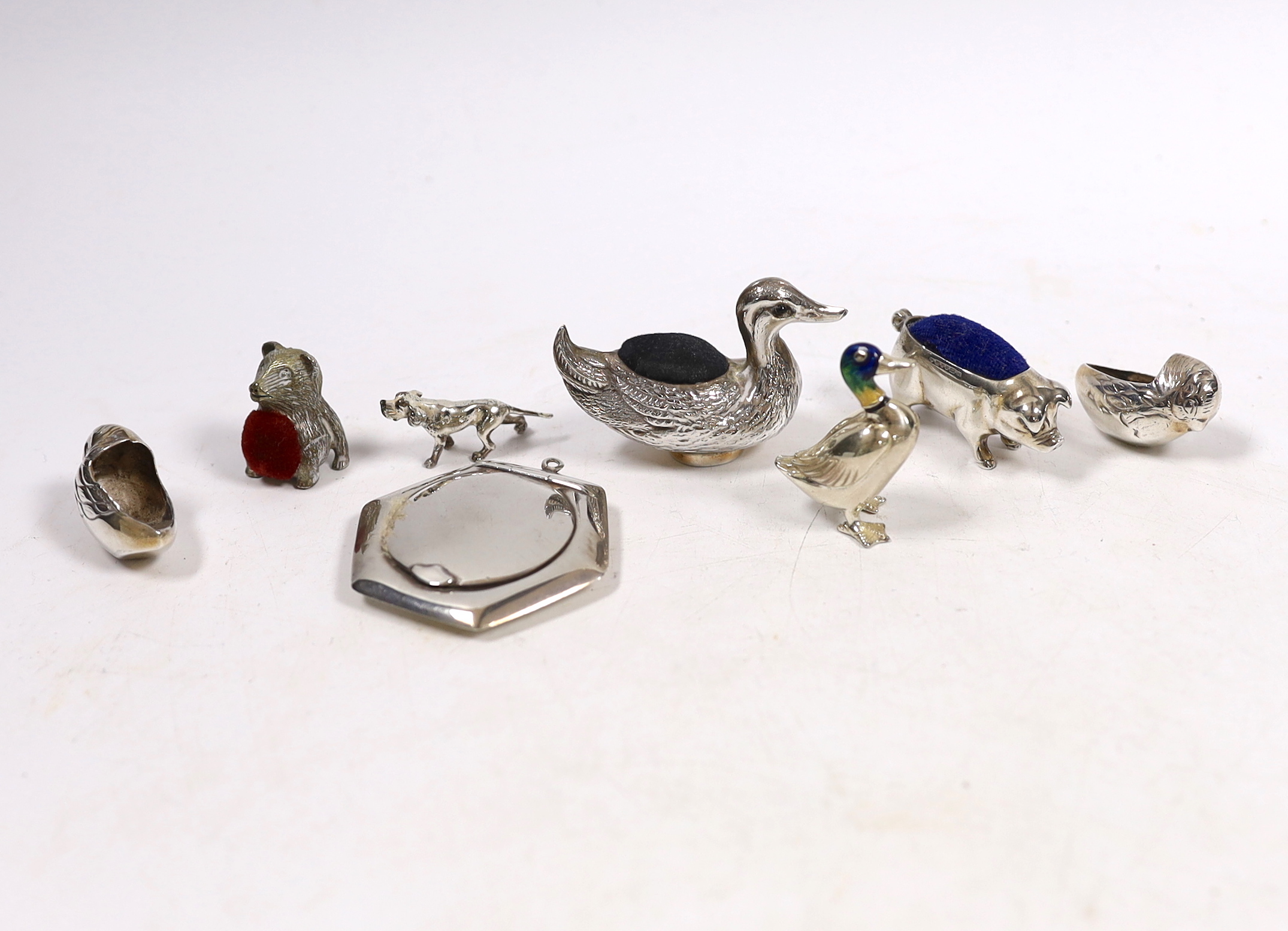 Five assorted modern silver mounted novelty pin cushions, including duck, pig and hatching chicks(lacking cushions), together with a silver and enamelled model of a duck, small silver compact and a small model dog.